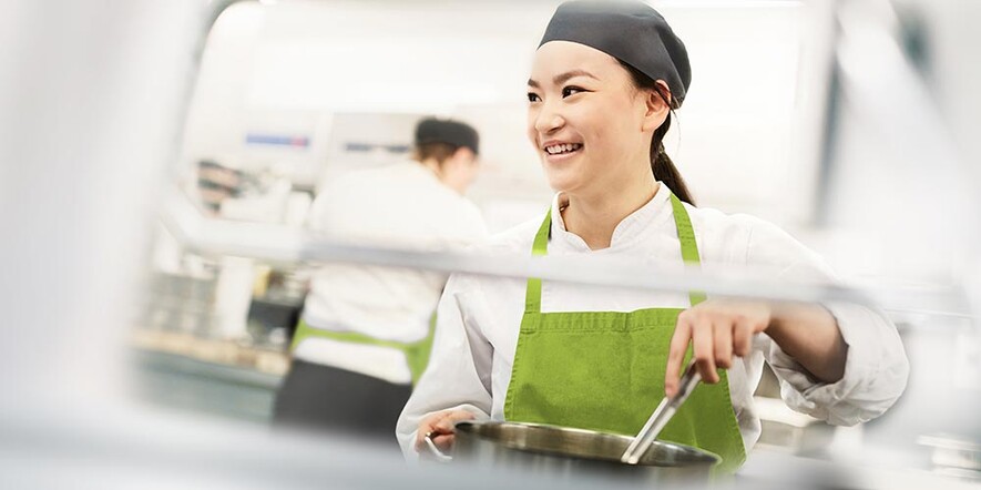 Asian woman stirring in cooking pot